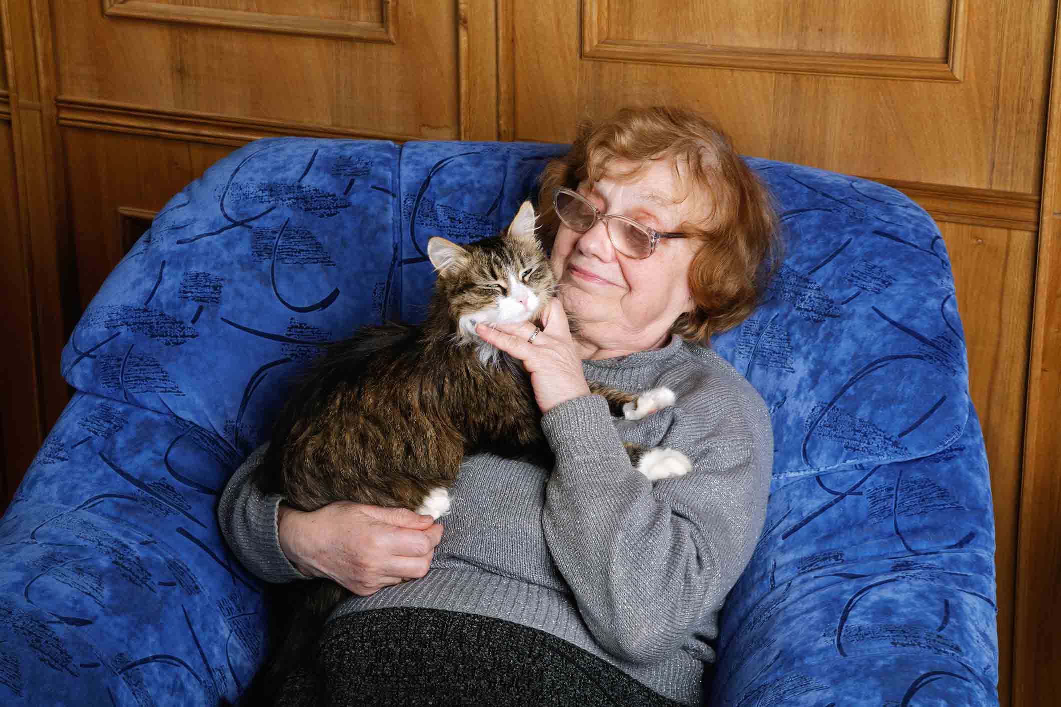 Mujer mayor con gato en su casa